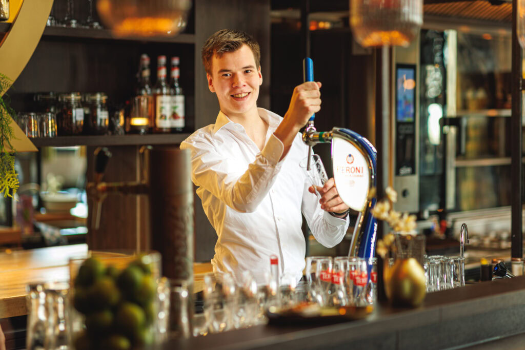 Man achter de bar tapt bier