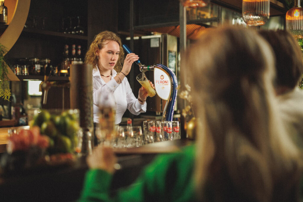 Een medewerker achter de biertap